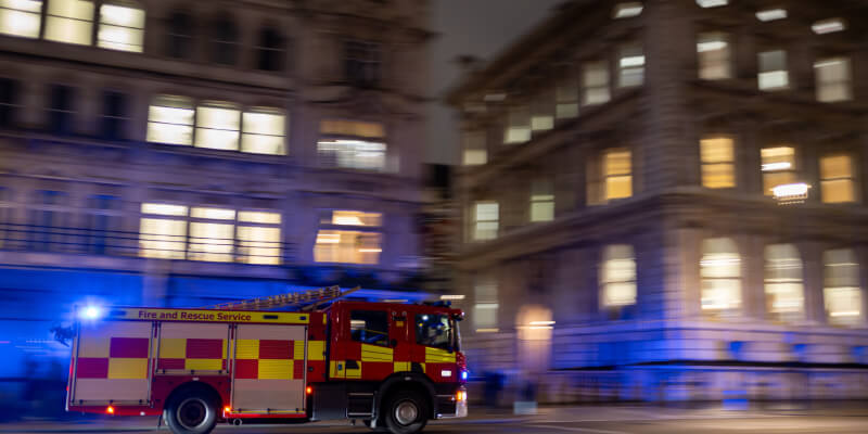 Fire engine driving at nighttime with background blurred
