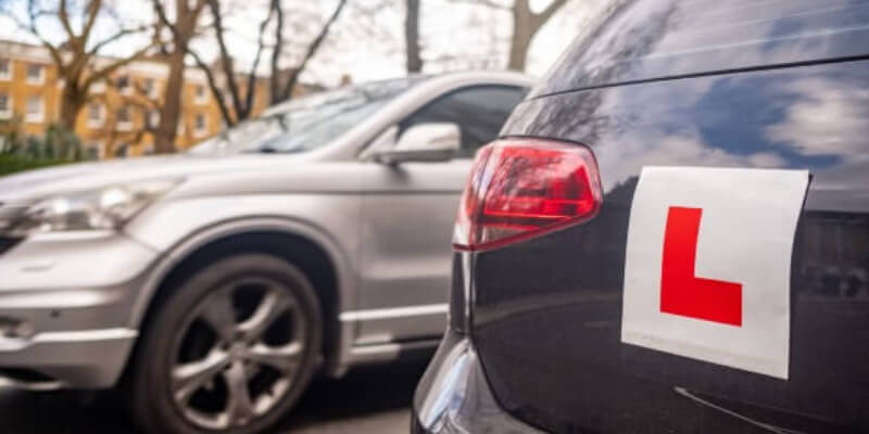 L-plate placed on the back of a parked car