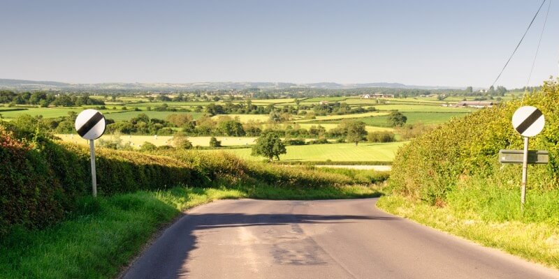 UK road with two national speed limits displayed on either side
